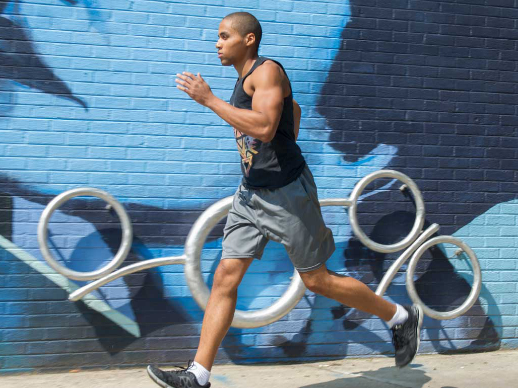 a person in athletic gear running on a colorful city street